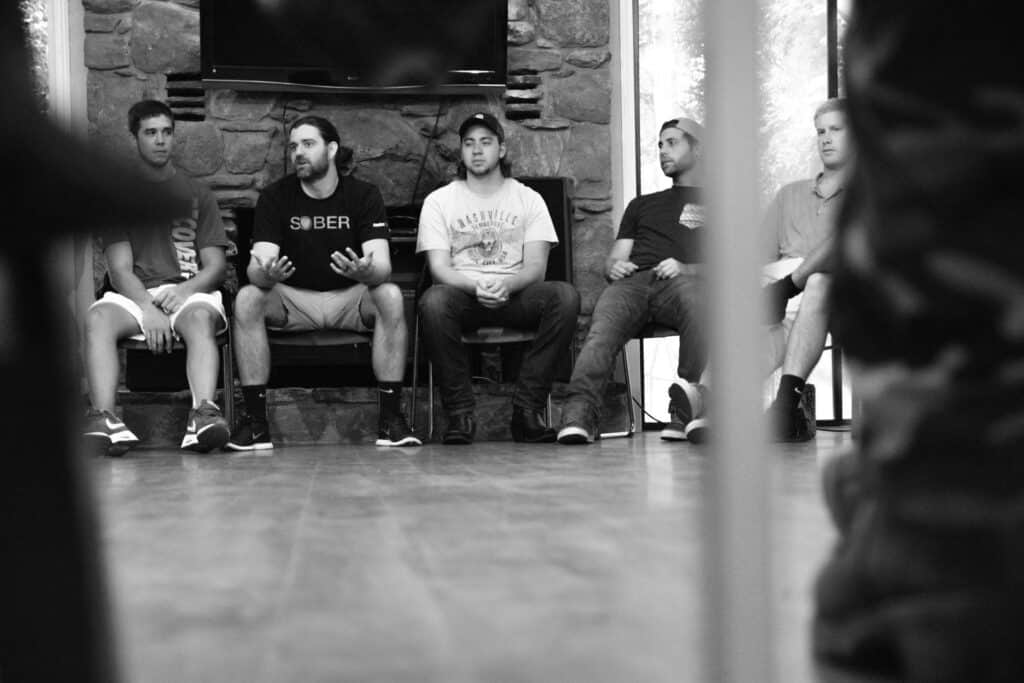 Men participating in group discussion about signs of a high functioning alcoholic