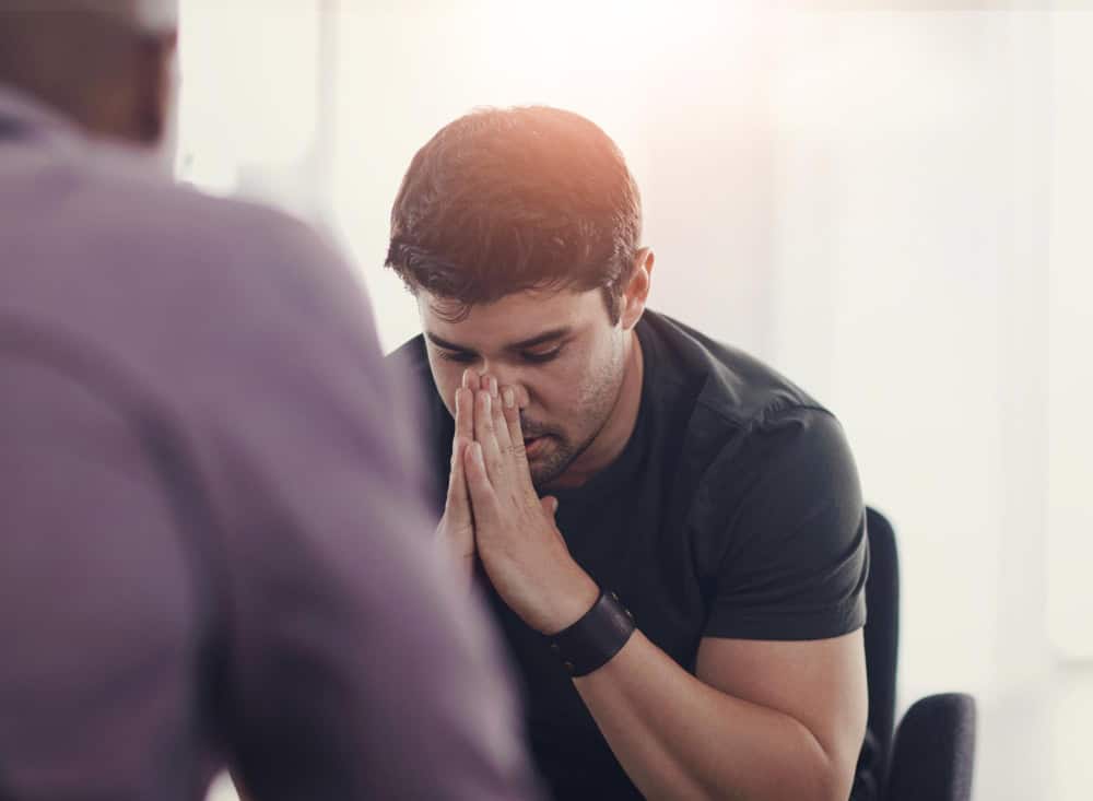 Distressed businessman experiencing workplace stress and anxiety during a financial crisis.