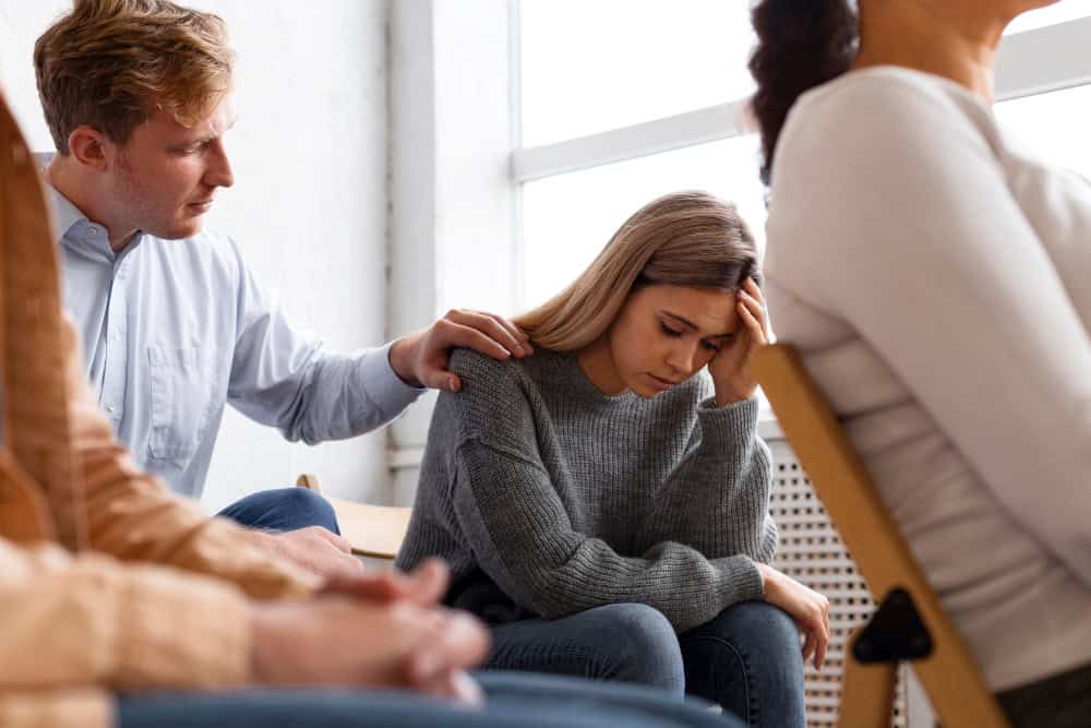 Sad woman participating in a group therapy session at a mental health treatment center in Lawrenceville, GA.