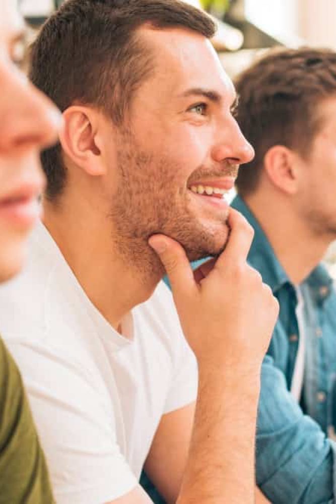 Three male friends participating in therapy during outpatient mental health treatment in Georgia.