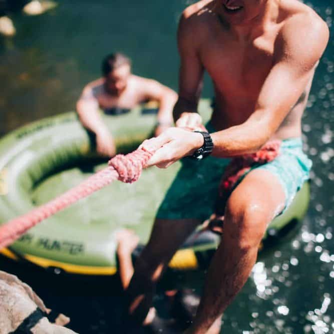 Man pulling rope on water float during outdoor activity after a alcohol addiction treatment lawrenceville, ga at Purple Treatment